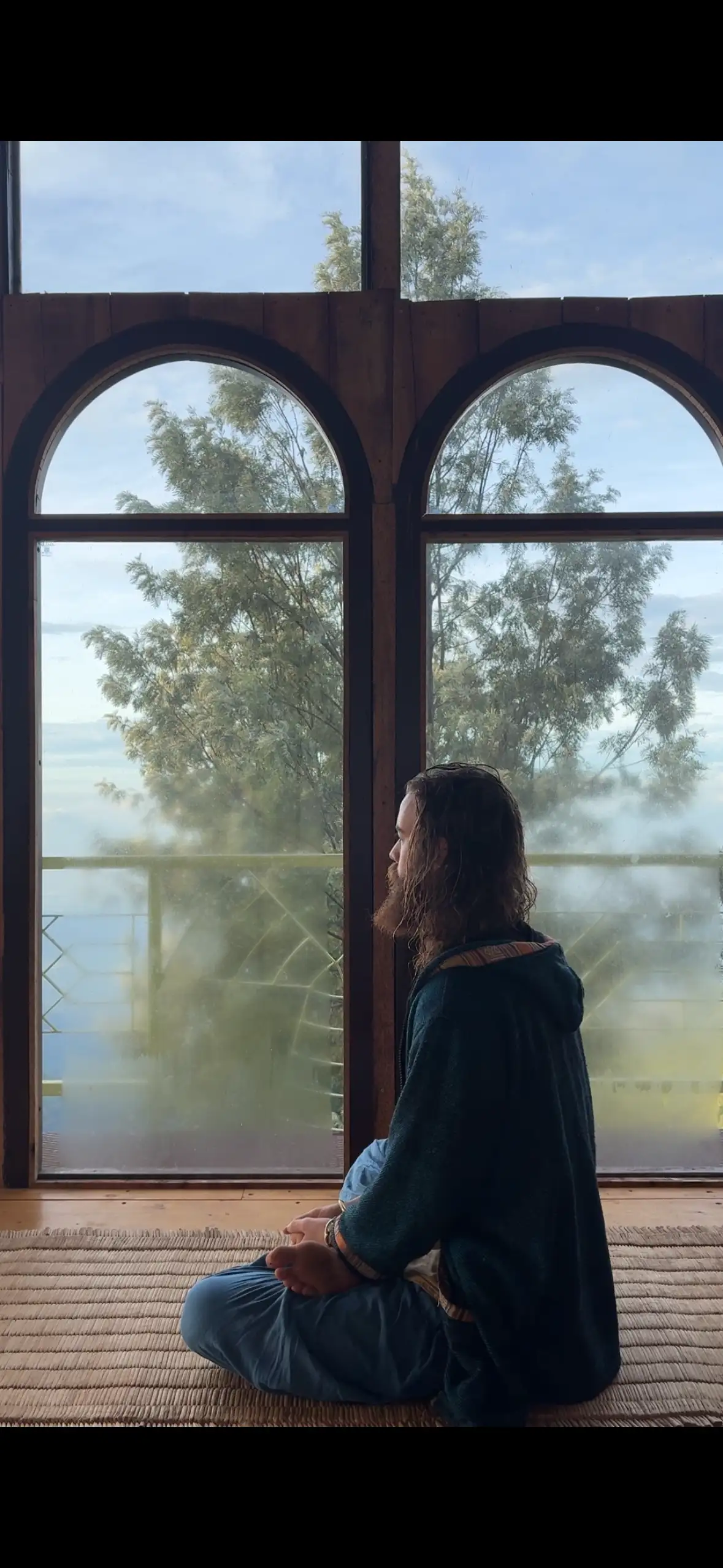 Michael sitting in meditation in a light-filled yoga hall